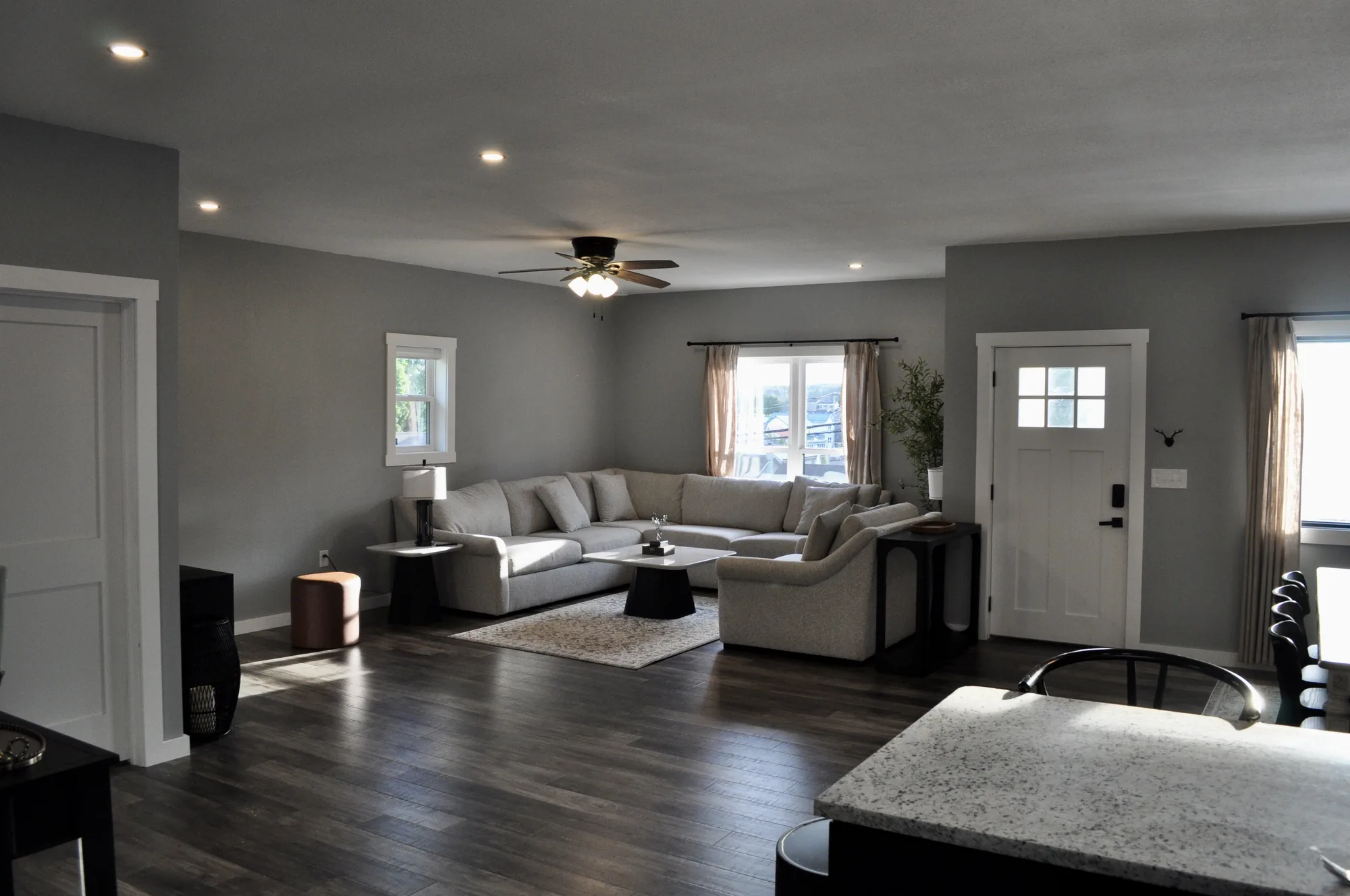 Open-concept great room with plush sectional and mountain-town views